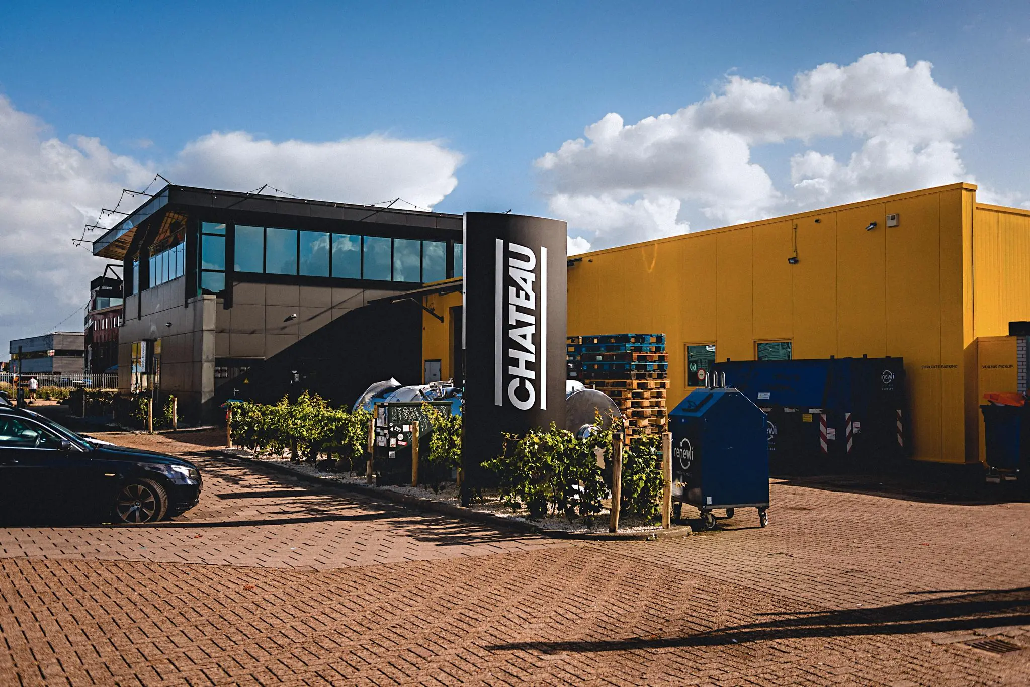 Bedrijfsgebouw en parkeerterrein aan de Johan van Hasseltweg met een zwart CHATEAU-bord en gele gevel.